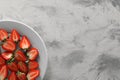 Food photography. Plate of delicious ripe strawberries on grey textured table, top view with space for text