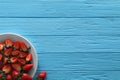 Food photography. Plate of delicious ripe strawberries on light blue wooden table, top view with space for text