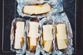 The food at the picnic. Grilled corn and cheese, wrapped in foil. The view from the top, above the grill Royalty Free Stock Photo