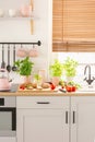 Food and pink accessories on countertop in bright kitchen interi