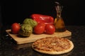 Food,pizza vegetables and oil on black background