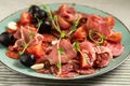 Food plate with delicious salami, sliced ham, sausage, tomatoes and black olives. Meat platter with cured meat on a Royalty Free Stock Photo