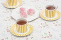 Food : Plate of pink iced sponge cakes and cups of tea. 1