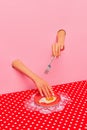 Food pop art photography. Female hand sticking out pink paper and cutting fried eggs on plate on retro tablecloth Royalty Free Stock Photo