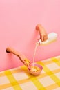 Food pop art photography. Female hands sticking out pink paper, pouring milk into bowl with corn flakes. Ordinary Royalty Free Stock Photo