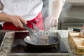 Food preparation chef cook in kitchen with pan over stove doing flambe crazy chef cooking with lamb Royalty Free Stock Photo