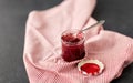 Mason jar with raspberry jam and spoon on towel Royalty Free Stock Photo