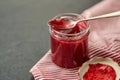 Mason jar with raspberry jam and spoon on towel Royalty Free Stock Photo