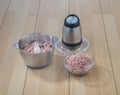 Food processor with mince pork on wooden table