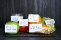 Food products with calorific value tags on black table. Weight loss concept