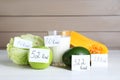 Food products with calorific value tags on white wooden table. Weight loss concept