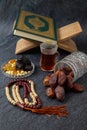 Food Ramadan Sweets mixed of dried fruits and nuts Glass Tea with rosary and the Quran on the table