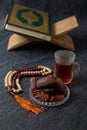 Food Ramadan Sweets mixed of dried fruits and nuts Glass Tea with rosary and the Quran on the table