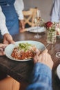 Food, restaurant and hands with a couple and waitress serving a pasta in a fine dining establishment. Date, romance and Royalty Free Stock Photo