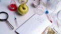 Food saferty lab. View of fresh ripe apple with test tubes and tools on table in research lab. Concept of genetic Royalty Free Stock Photo