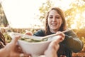 Food, salad and healthy eating outdoor with woman giving or serving bowl with vegetables on patio for Christmas or Royalty Free Stock Photo