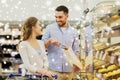 Happy couple with shopping cart at grocery store Royalty Free Stock Photo