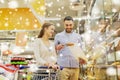 Happy couple with shopping cart at grocery store Royalty Free Stock Photo