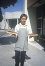 A food server carrying cherry pies