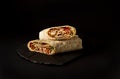 Shawarma, roll in lavash , grilled meat, with vegetables, sandwich , cut on a black background, horizontal, copy spase Royalty Free Stock Photo