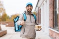 happy delivery man with thermal bag and coffee Royalty Free Stock Photo