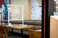 Food shop in a mall have a plastic shield partition on the tables,restaurant with plastic shield as a barrier to sit or eat by Royalty Free Stock Photo