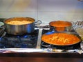 Food simmering in pots and pans in restaurant kitchen