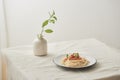 Food, spaghetti bolognese sauce in white dish and a vase of plants on a white prepared table Royalty Free Stock Photo