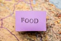 Food stencil text on purple paper over a map.. Royalty Free Stock Photo