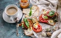 Food still life: cup of coffee, Italian toasts with cheese, tomatoes, basil, quail eggs. Ideas for a tasty and healthy breakfast