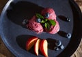 Still life. Refreshing vegan huckleberry sorbet, on navy plate, topped with mint leaves, blueberries and juicy peaches. Royalty Free Stock Photo