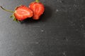 food strawberry berries whole and cut in half on a grey stone black stone side frame Royalty Free Stock Photo