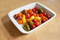 Food stuff. Closeup of roma or cherry tomatoes in a glass bowl served on a wooden table for diet, healthy salads and