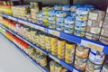 Various tinned foods and vegetables preserved in jars display on shelves in a supermarket,