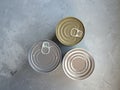 Various canned foods in tin cans on concrete grey background. Non-perishable, long shelf life food for survival in