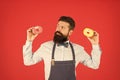 The food tastes so good. Professional baker with freshly baked dessert food on red background. Bearded man holding Royalty Free Stock Photo