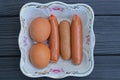 food of three boiled sausages and two brown chicken eggs Royalty Free Stock Photo