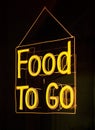 Food to Go Neon Sign hung on a dark wall