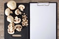 Food. Top view mushrooms on a black cutting board. To cook the champignon. Write down the recipe. Copy space, clear space. Tablet Royalty Free Stock Photo