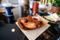 Food Tray of chicken wings with sauce on a napkin on a table Royalty Free Stock Photo