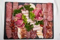 Food tray with delicious salami, pieces of sliced ham, sausage, salad - Meat platter with selection Royalty Free Stock Photo