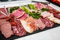 Food tray with delicious salami, pieces of sliced ham, sausage, salad - Meat platter with selection Royalty Free Stock Photo