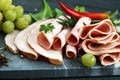 Food tray with delicious salami, pieces of sliced ham, sausage, tomatoes, salad and vegetable - Meat platter with selection Royalty Free Stock Photo