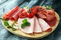 Food tray with delicious salami, pieces of sliced ham, sausage, tomatoes, salad and vegetable - Meat platter with selection. Royalty Free Stock Photo