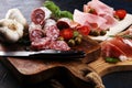 Food tray with delicious salami, pieces of sliced prosciutto crudo, sausage and basil. Meat platter Royalty Free Stock Photo