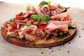 Food tray with delicious salami, pieces of sliced prosciutto crudo, sausage and basil. Meat platter Royalty Free Stock Photo