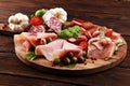 Food tray with delicious salami, pieces of sliced prosciutto crudo, sausage and basil. Meat platter Royalty Free Stock Photo