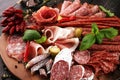 Food tray with delicious salami, pieces of sliced prosciutto crudo, sausage and basil. Meat platter with selection Royalty Free Stock Photo