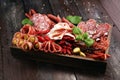 Food tray with delicious salami, pieces of sliced prosciutto crudo, sausage and basil. Meat platter with selection Royalty Free Stock Photo