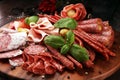 Food tray with delicious salami, pieces of sliced prosciutto crudo, sausage and basil. Meat platter with selection Royalty Free Stock Photo